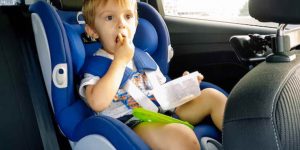 criança comendo no carro